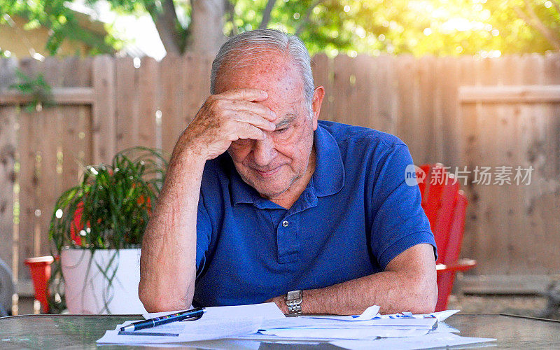 由于经济衰退，压力大的老人在看他过去到期的账单