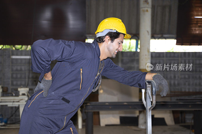 蓝领工人在工厂里操作机器。