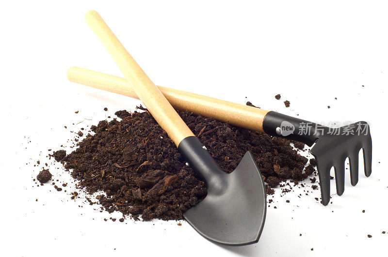 用花园铁锹和耙子耙在泥炭土上