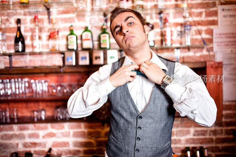 愤怒和紧张的酒吧服务员的肖像与领结后面的酒吧