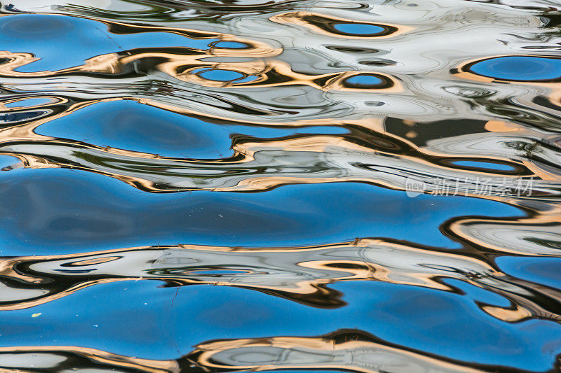 抽象在马六甲运河的水面上泛起金色和蓝色的涟漪。