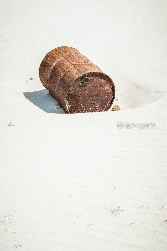 海滩上生锈的油桶