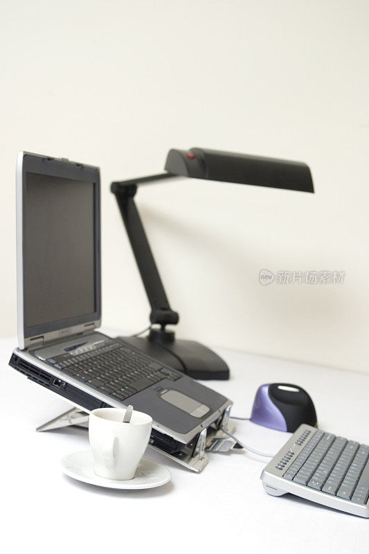 白色办公桌，笔记本，键盘，鼠标和咖啡杯