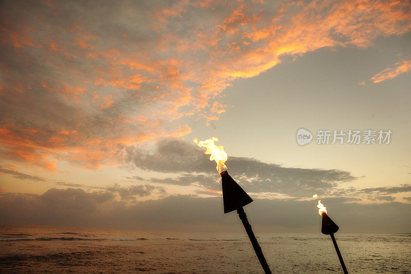 夏威夷海滩上的日落与提基灯