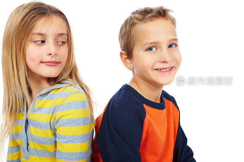 两个孩子背靠背坐在白色背景的特写