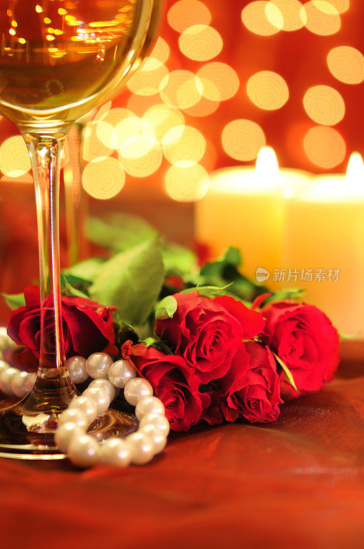 红玫瑰伴着美酒和烛光