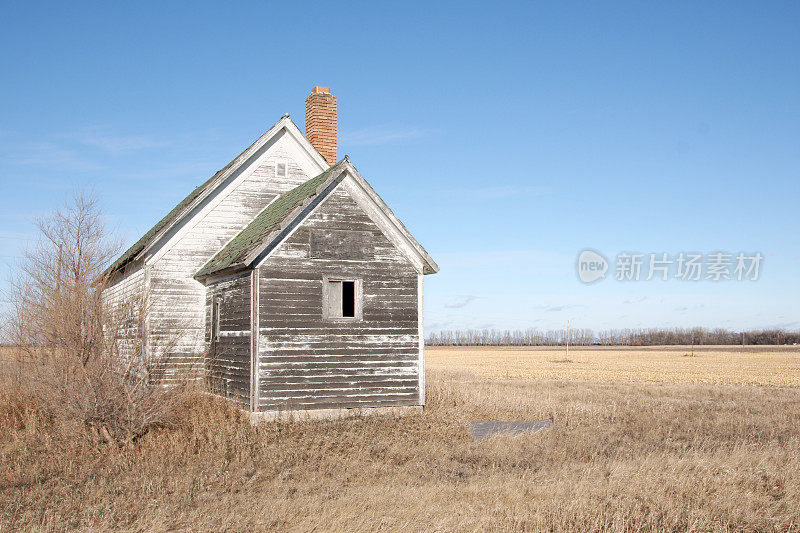 残茬地里的小型风化木建筑。