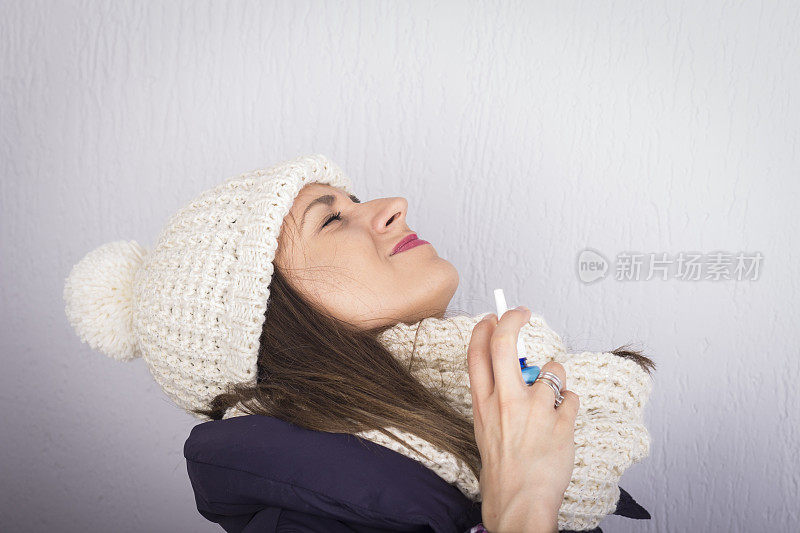 一个年轻女人在用喷喉剂。