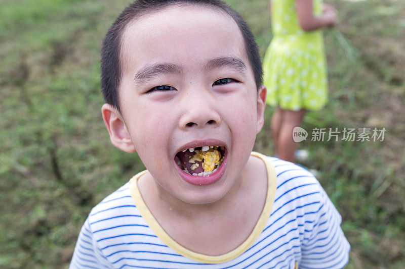 嘴里叼着生玉米的中国男孩