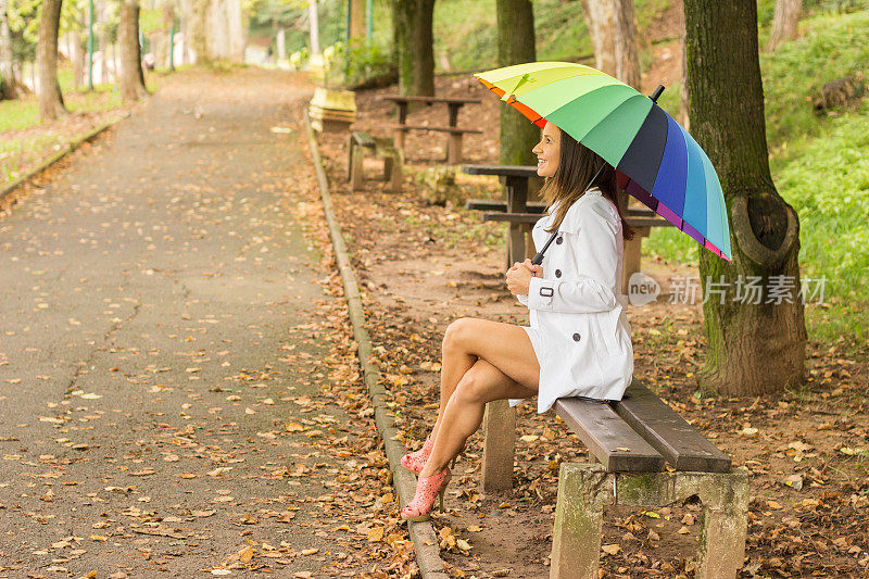 黑发女孩在森林里拿着五颜六色的雨伞