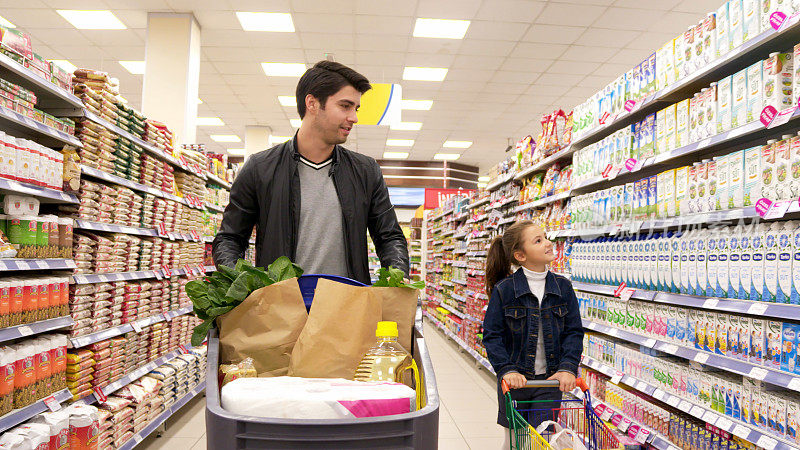 年轻的父亲和女儿在超市购物