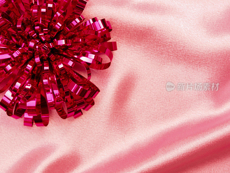 粉红色缎子上的金属品红色蝴蝶结
