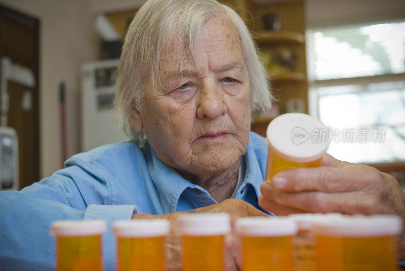 困惑的老女人看着药瓶