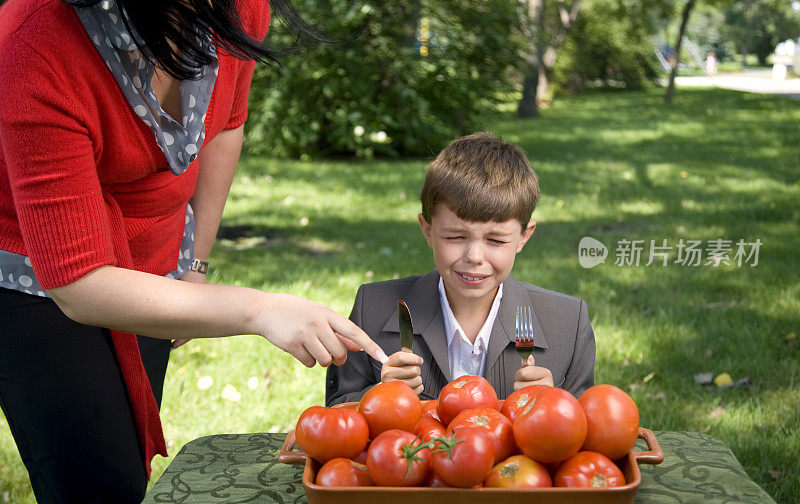 男孩哭，因为他不想吃蔬菜