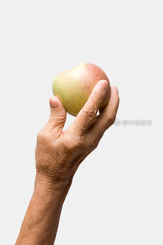 老妇人的手拿着一个苹果
