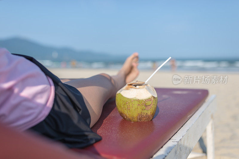 在海滩享受夏日日光浴和热带饮料