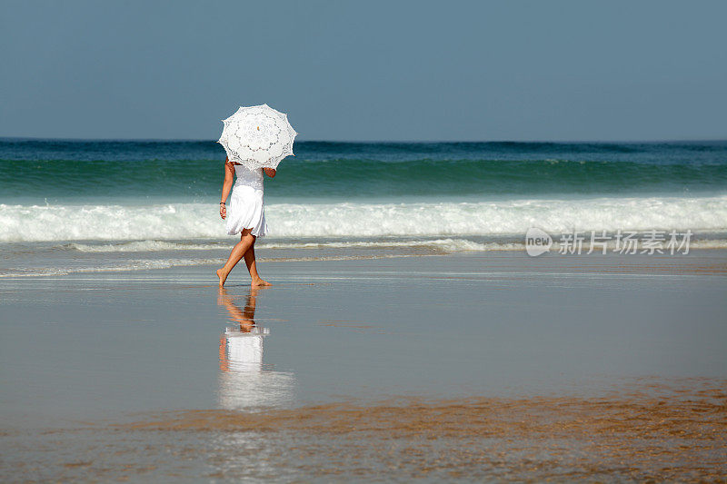 打着白色阳伞的女子赤脚走在沙滩上(XXL)