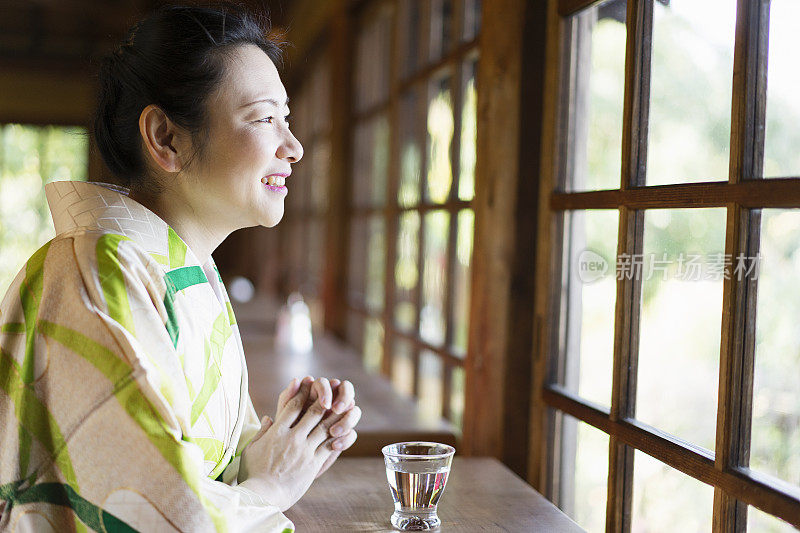 成熟的女人穿着和服，在咖啡馆放松