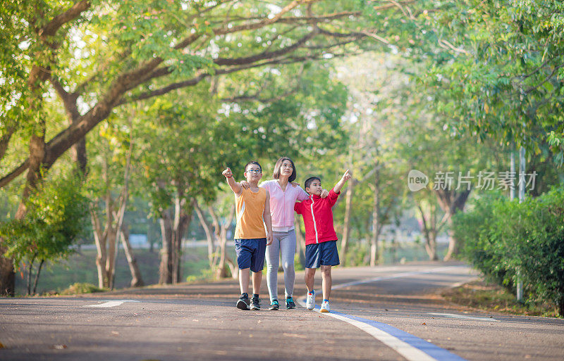 家庭运动快乐活跃的母亲和孩子在户外慢跑，在森林里跑步