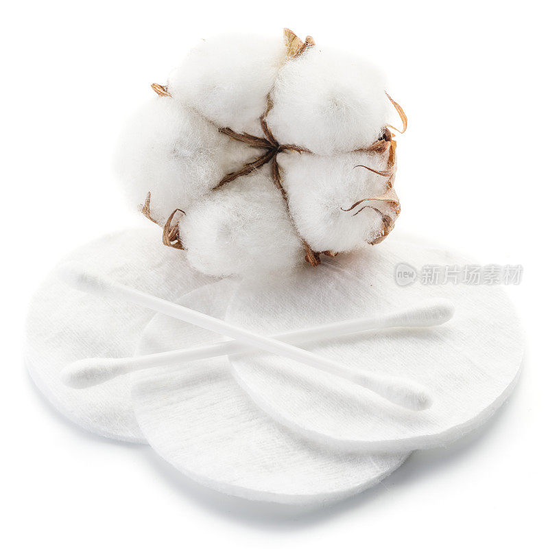 白色背景上蓬松的棉球、棉签和棉垫。