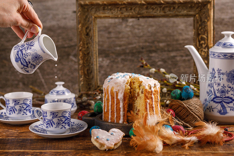 复活节茶，就是把牛奶倒进一杯茶里。节日自制糖霜蛋糕。桌子上有复活节的装饰品。