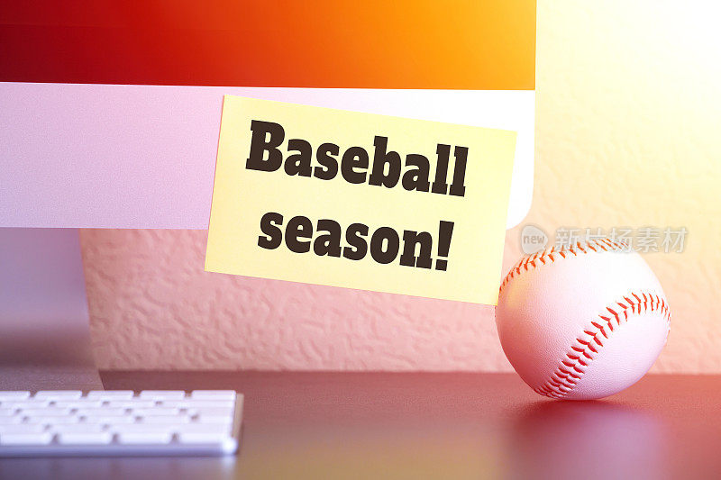 棒球近旁用黄色贴纸贴着提醒电脑上有文字:棒球赛季!