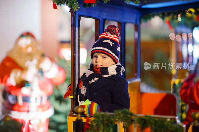 圣诞市场上旋转木马上的小男孩