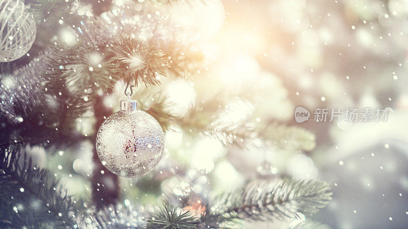 白色和银色的小装饰品挂在装饰好的圣诞树上。