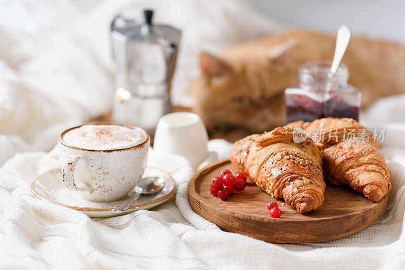 早餐在床上，咖啡，牛角面包和果酱