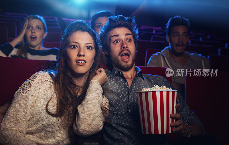 一对年轻夫妇在电影院看恐怖电影