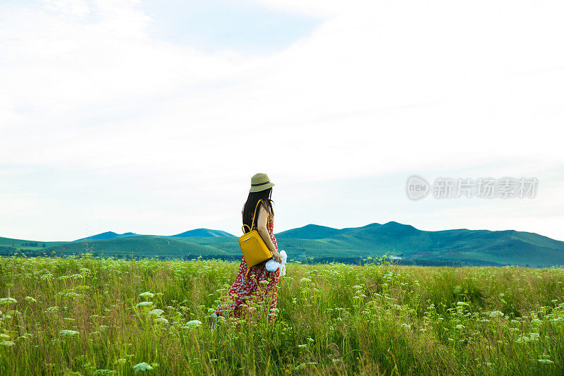 年轻女子在草原上行走