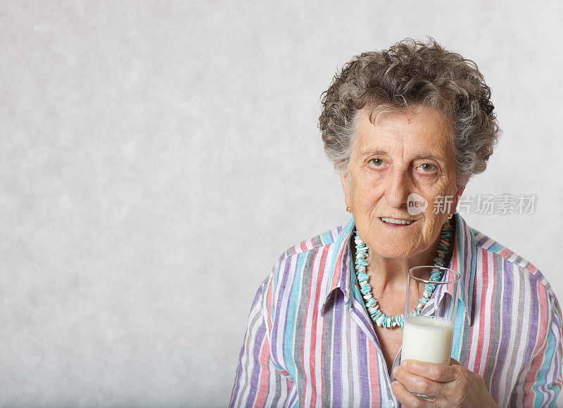 老年妇女70到80岁之间的一杯牛奶。