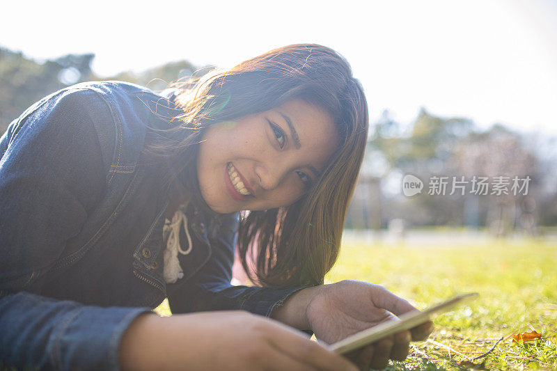 一个年轻女子躺在绿色的草地上的肖像