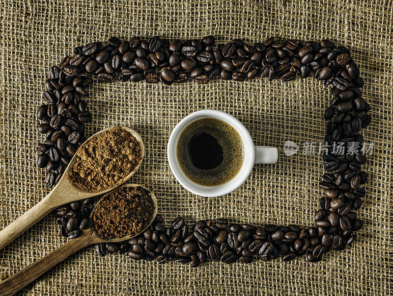 一杯浓缩咖啡和烤生咖啡豆在黄麻背景上做一个框架