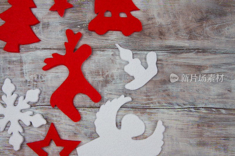 红色和白色的圣诞装饰:麋鹿，天使，汽车，星星，树。木制背景。