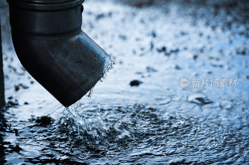 排水管在雨中，人行道上