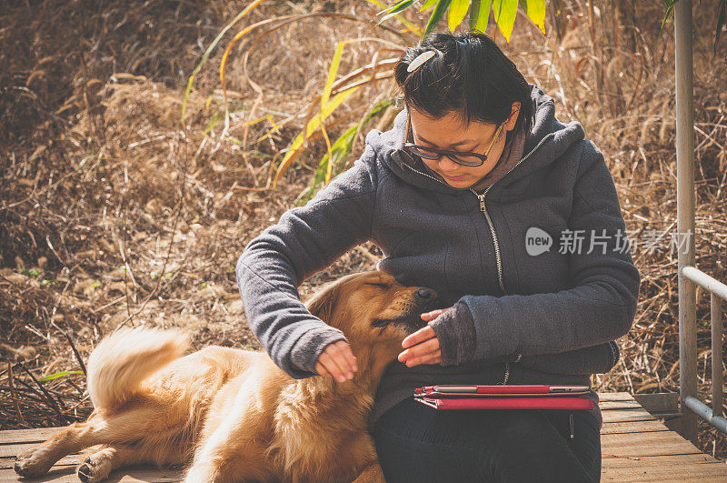 一个亚洲女人和一只金毛猎犬