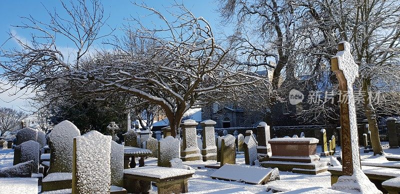 白雪覆盖的墓地里的坟墓、墓碑和墓碑