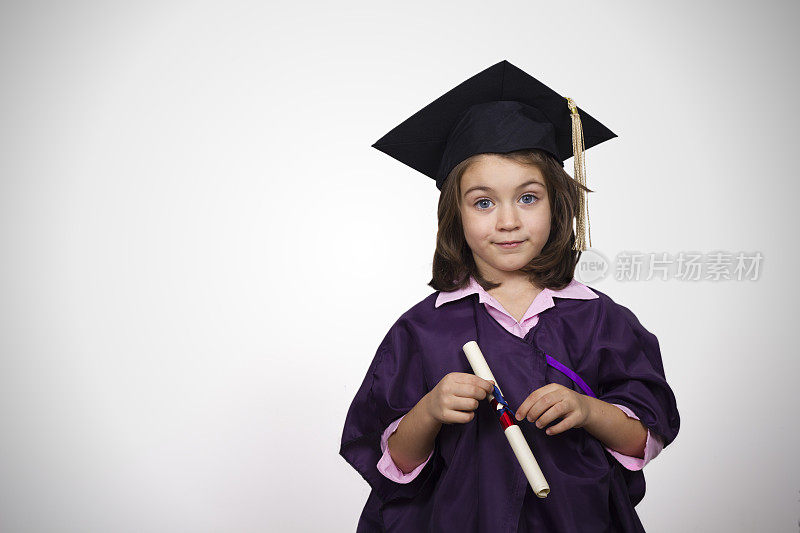 年轻的女孩穿着毕业礼服和学位证书