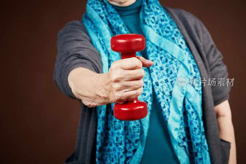 老年健身:女人手握红手重量