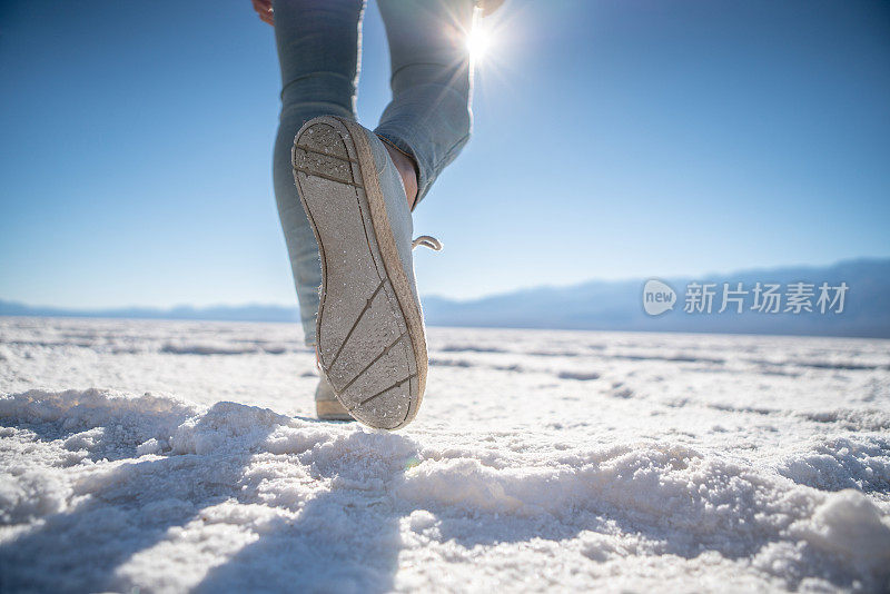 年轻女子站在沙漠的盐滩上凝视壮观的风景;女孩旅行，发现世界