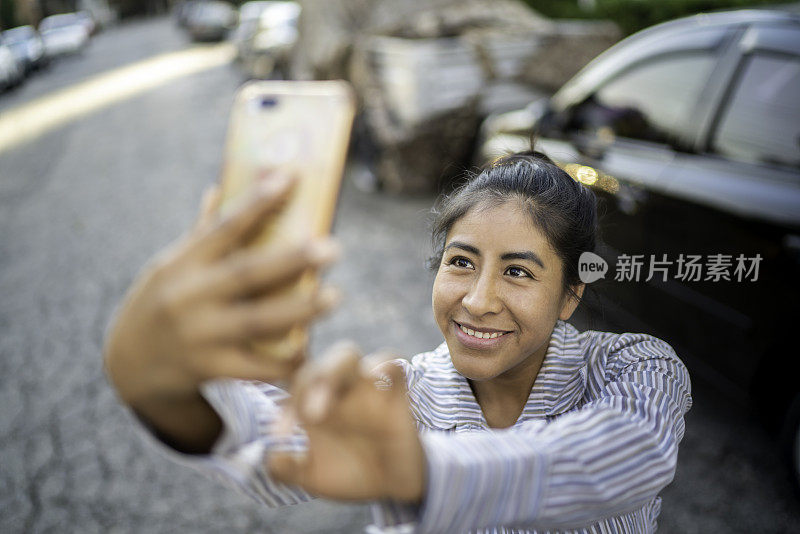 一个拉丁女人在城市街道上自拍