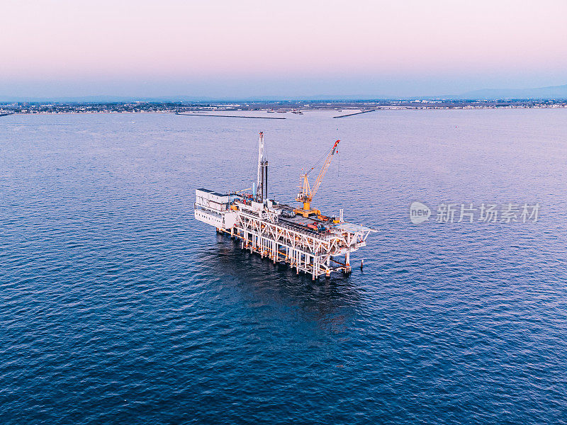 加利福尼亚州亨廷顿海滩日落时海上石油钻井平台的高角度视图