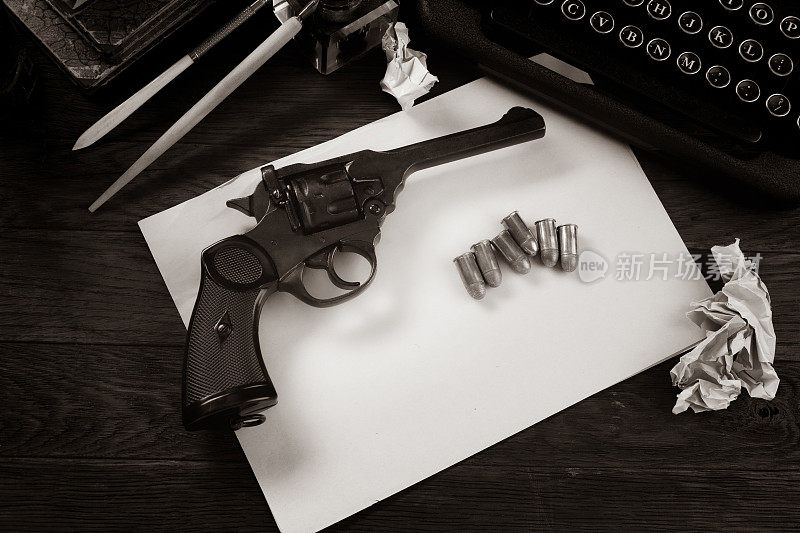 Сrime小说-旧的复古老式打字机和左轮手枪与弹药，书，白纸，旧墨水笔