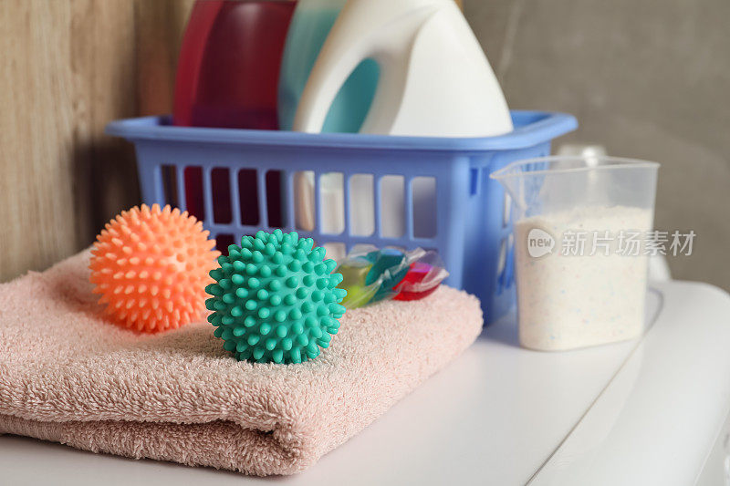 洗衣机上的干衣球、清洁剂和干净毛巾