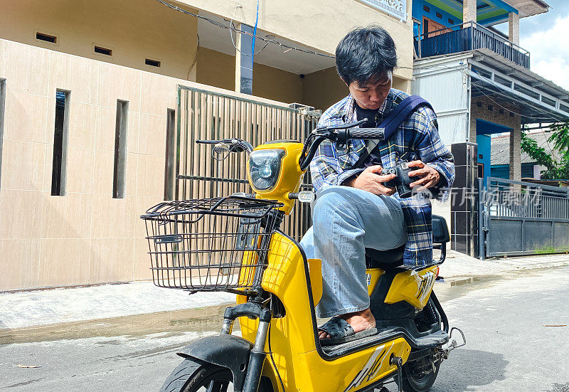 在居民区骑电动自行车的年轻人