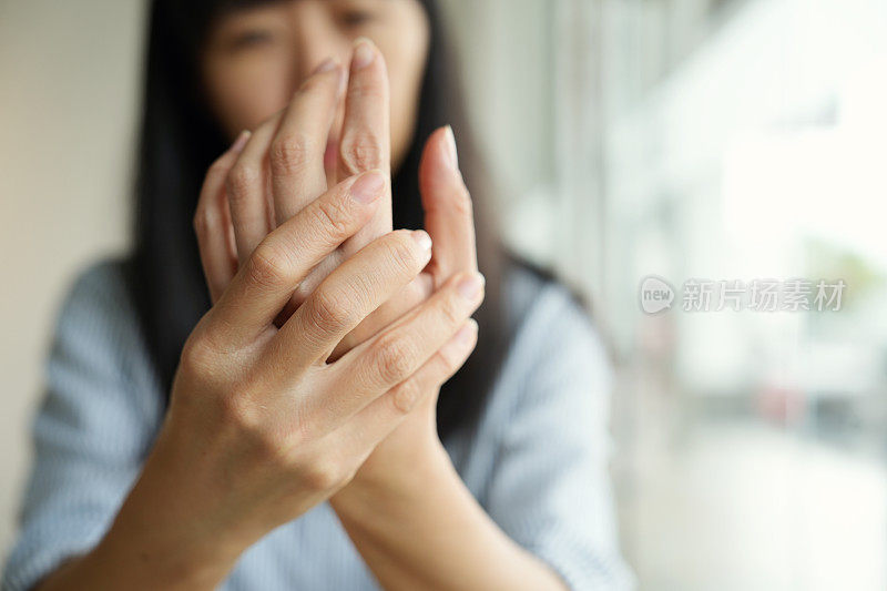 特写妇女按摩她的关节炎手和手腕，她是痛苦和风湿。