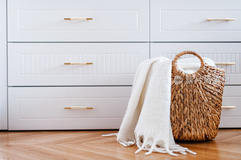 衣柜抽屉和编织柳条篮洗衣与白色毯子，关闭。