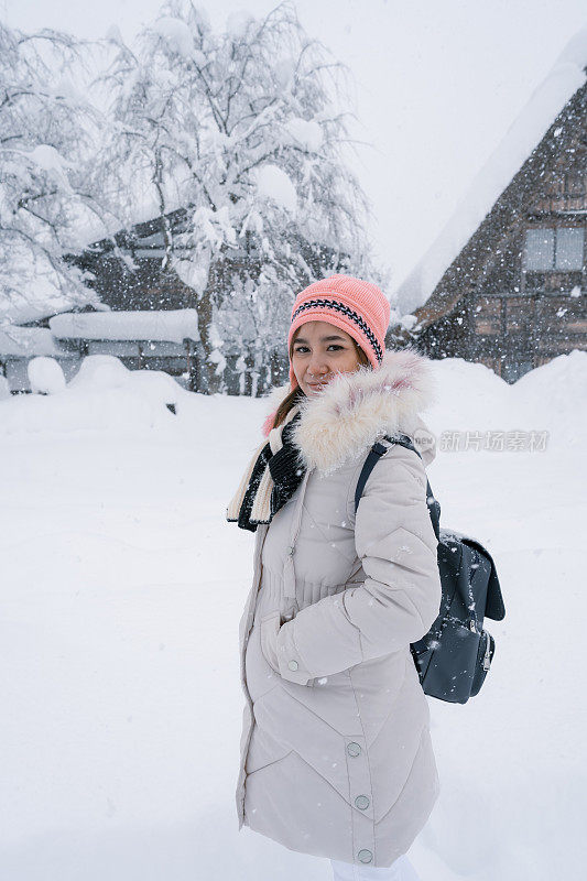 美丽的女游客们享受着白川村的旅行，冬天的日本有厚厚的积雪