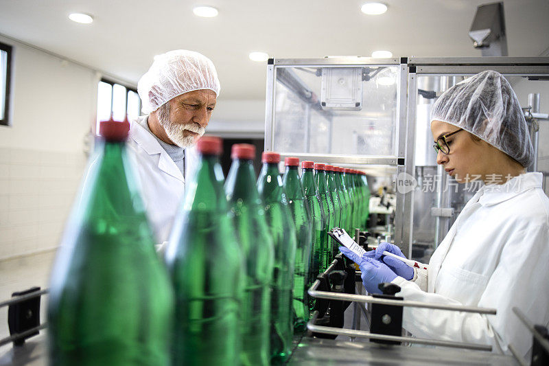 质量控制检查员检查装瓶厂的水生产。
